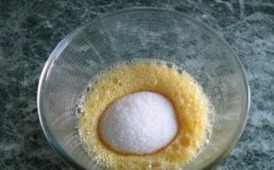Взбитые яйца засыпаем сахаром и выливаем остывшее масло