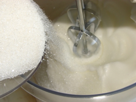 Процесс взбивания белков с постепенным добавлением сахара