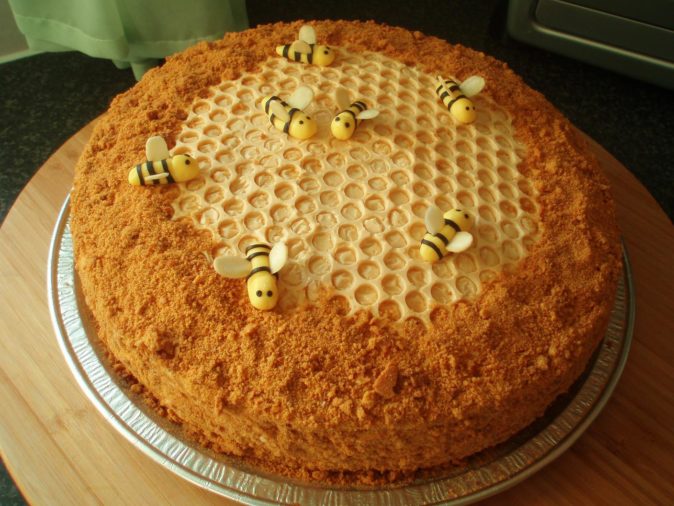 Готовый медовый торт, украшенный пчелами и сотами
