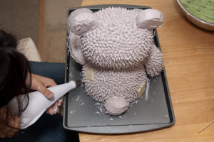 Собранный торт в виде мишки Тедди, украшенный кремом